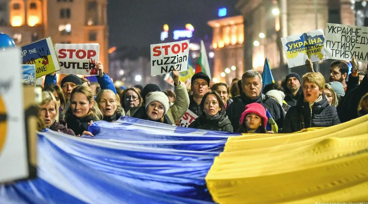 Участники демонстрации в поддержку Украины несут украинский флаг в столице Болгарии Софии